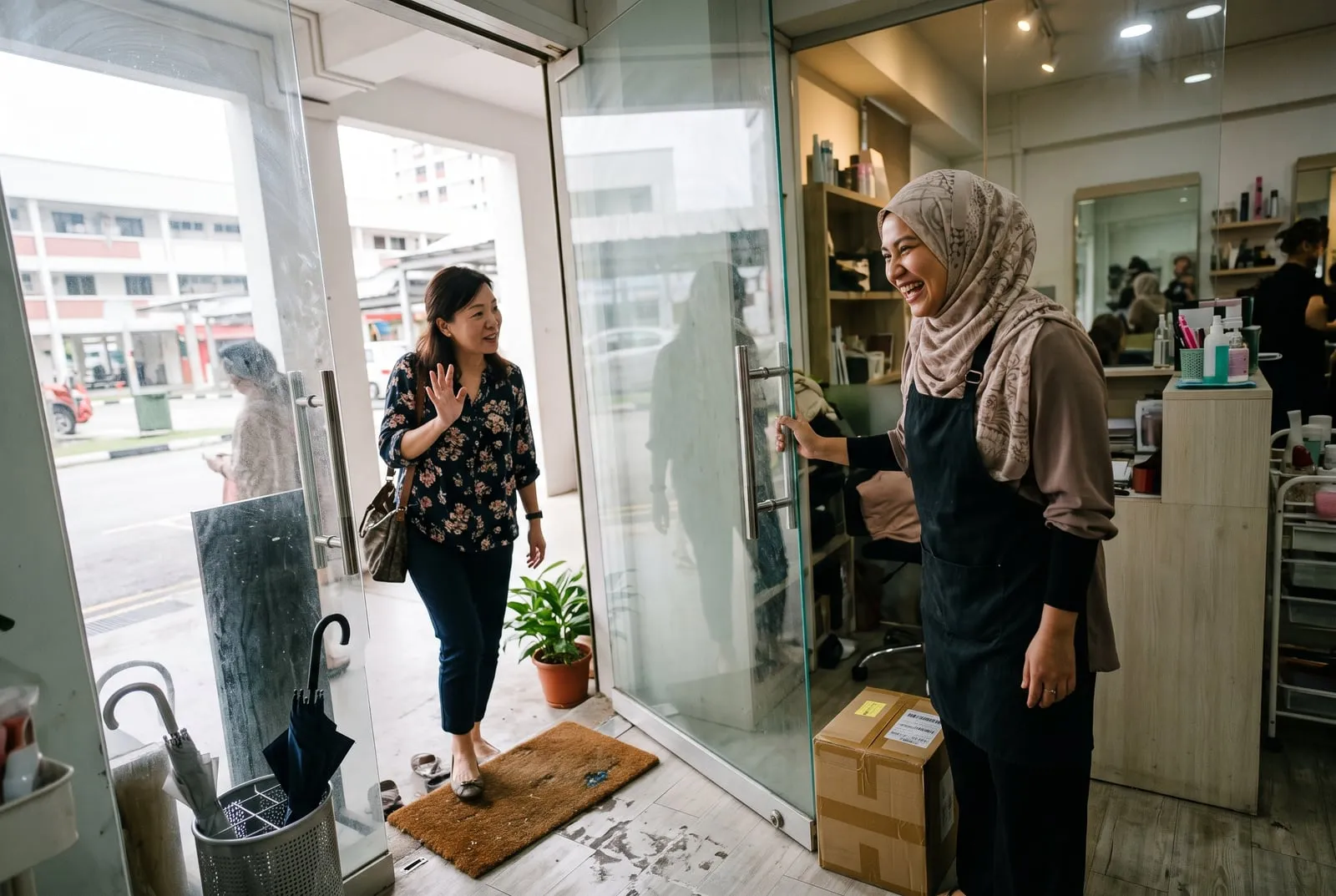 A studio owner welcoming a returning customer at the door, both mid-laugh.